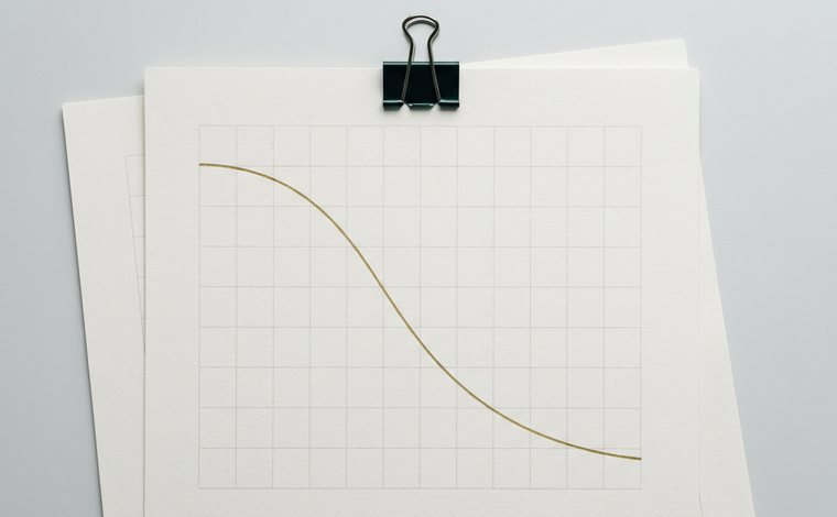 Gráfico de provisão impresso, visto de cima, preso por um clipe preto